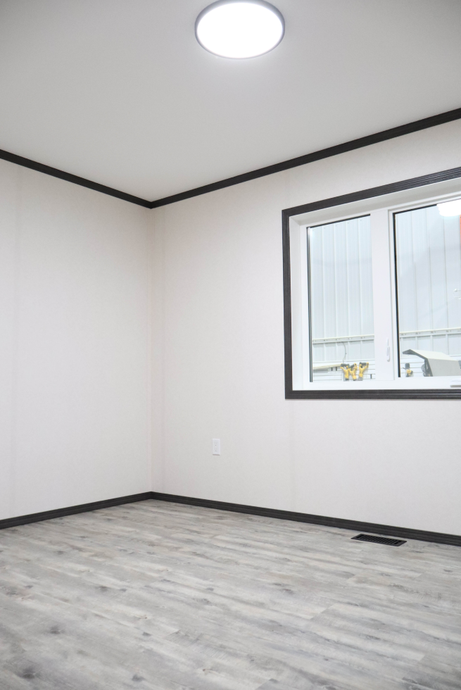 Corner bedroom featuring natural light in modular home